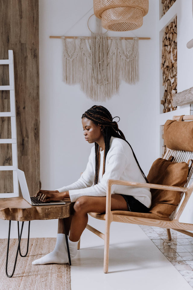 Black woman using computer in a cozy living room