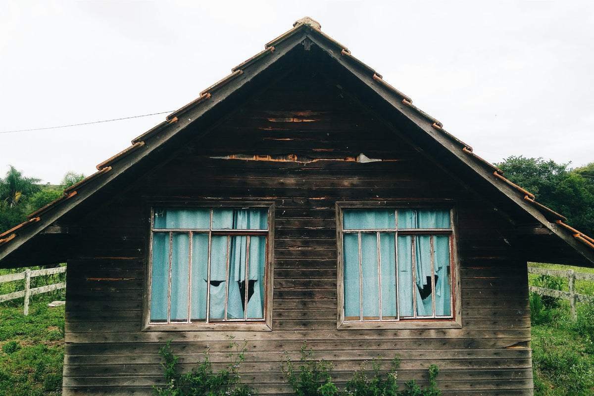 Rustic looking wooden house with blue curtains