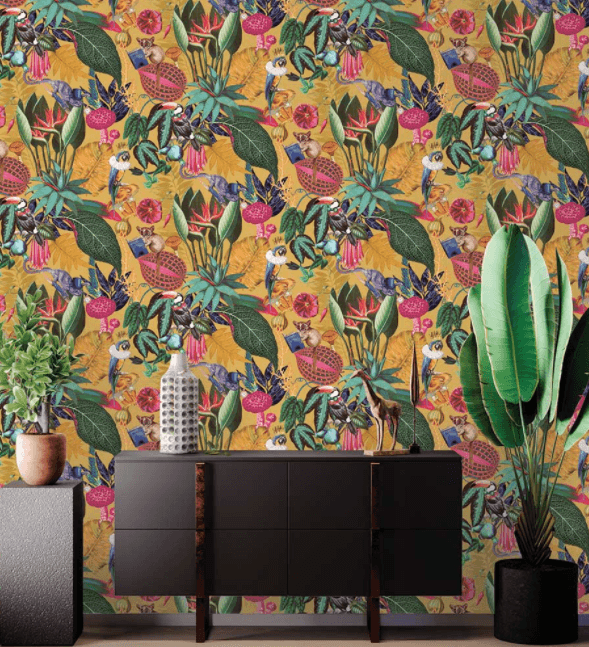 Wallpaper of a fantastical jungle scene with a monocle-wearing bush baby and a parrot with a crown. Also features exotic leaves, mushrooms, fruit, and flowers, with toucan and lizard characters. Multi-colored with a rich ochre yellow background.